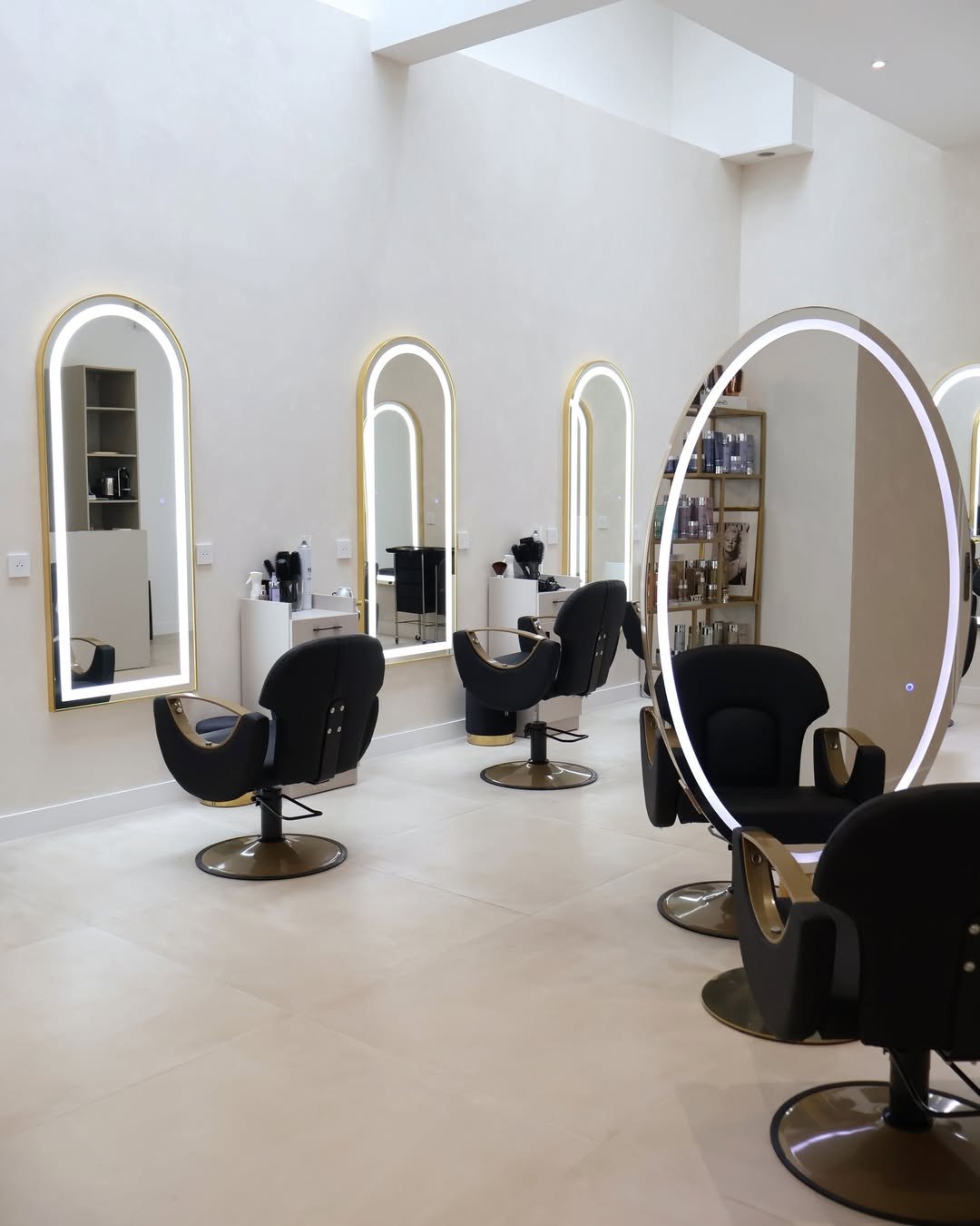 Espace AURA Women — miroirs dorés en arche et fauteuils noir & or